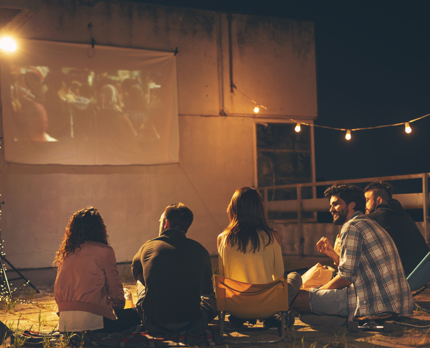 Group-of-Friends-Watching-Projector-Outdoors