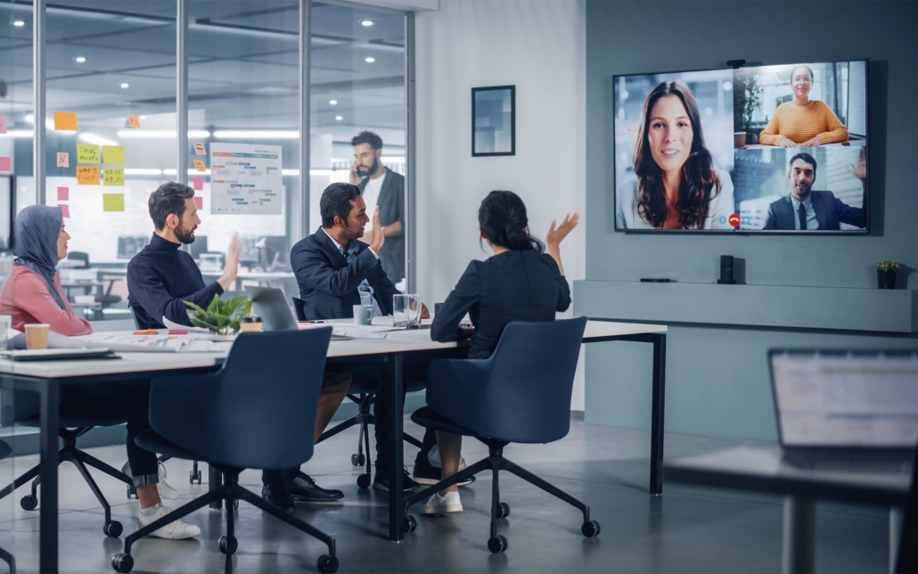 Workers talking with remote employees over TV